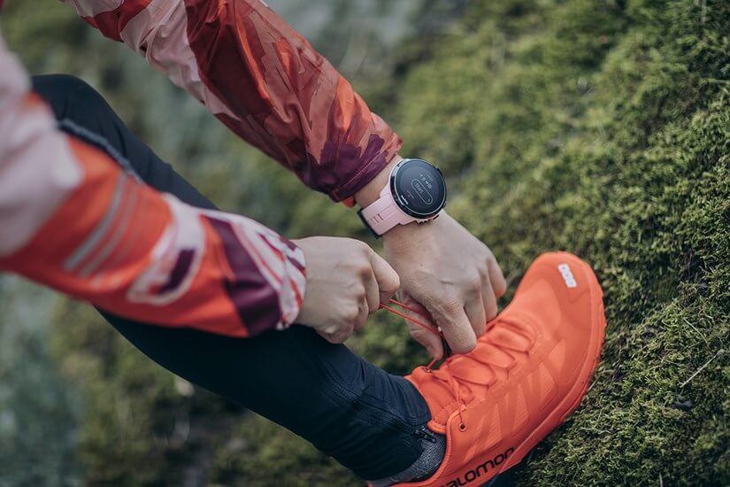 Спортсмен завязывает шнурки, на руке Suunto Spartan Sport Wrist HR Sakura